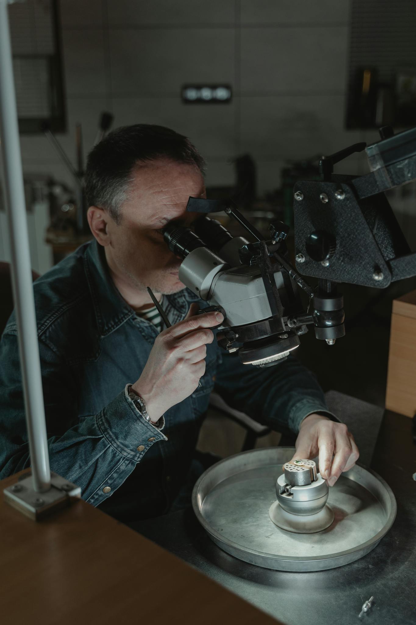 Close-up of a jeweler using a magnifying tool for precise craftsmanship indoors.