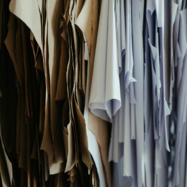 Detailed view of hanging fabric patterns in a fashion design workshop.